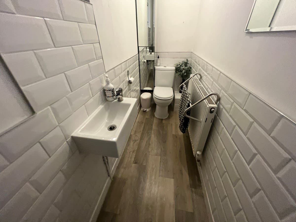 Shower room — bevel tile, wall-hung basin, vertical radiator