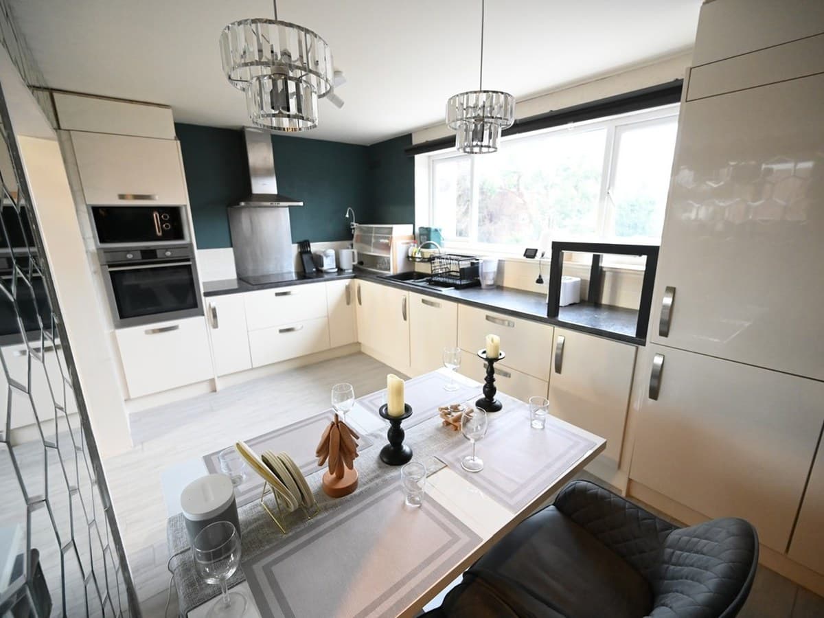 Kitchen and dining in one room, under a cut-glass pendant